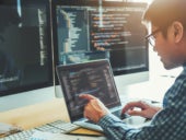 Programmer encoding on a laptop in an office setting.