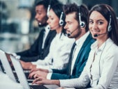 Employees in call center sitting at computers and working.